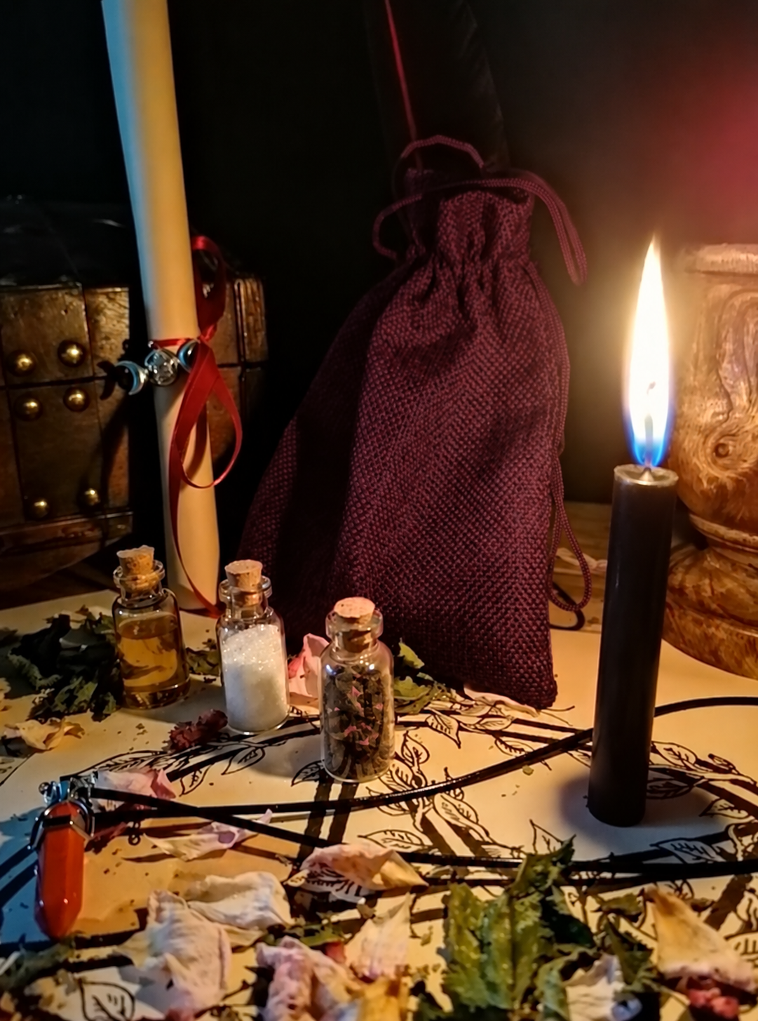 Illustrative scene for Custom Black Magic Spell with a candle, dried plants and small glass vials, adapted from the shared ritual setting.