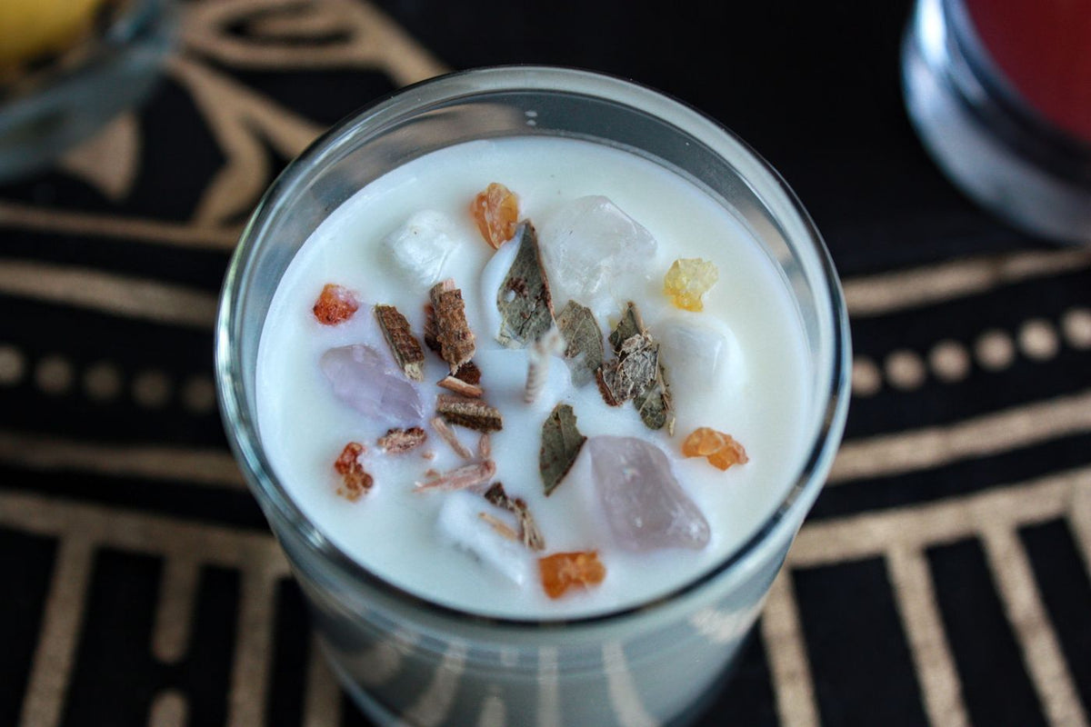 Handmade candle with dried herbs and small stones