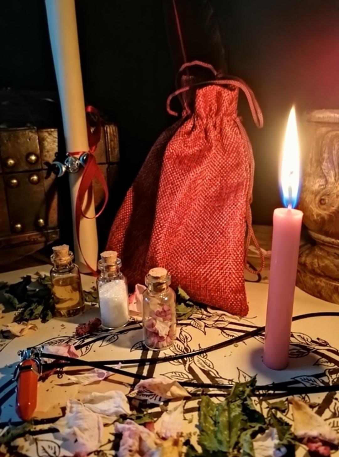 Illustrative scene for Relationship Interference Removal with a candle, dried plants and small glass vials, adapted from the shared ritual setting.