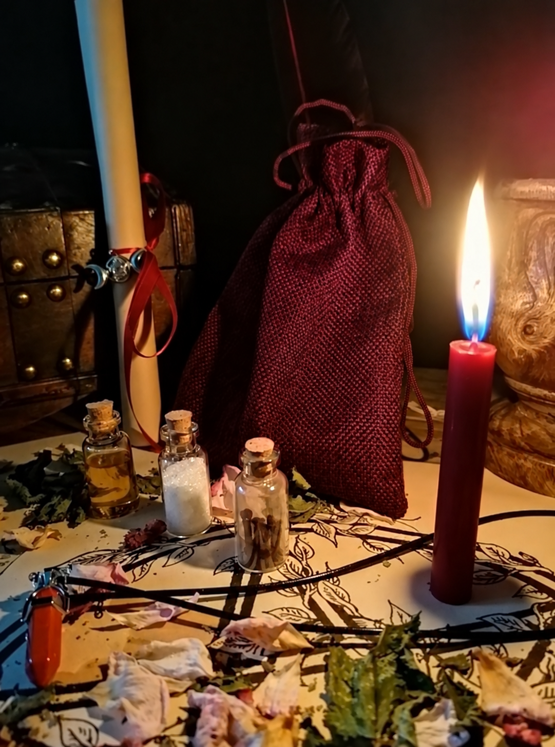 Illustrative scene for Revenge Spell with a candle, dried plants and small glass vials, adapted from the shared ritual setting.